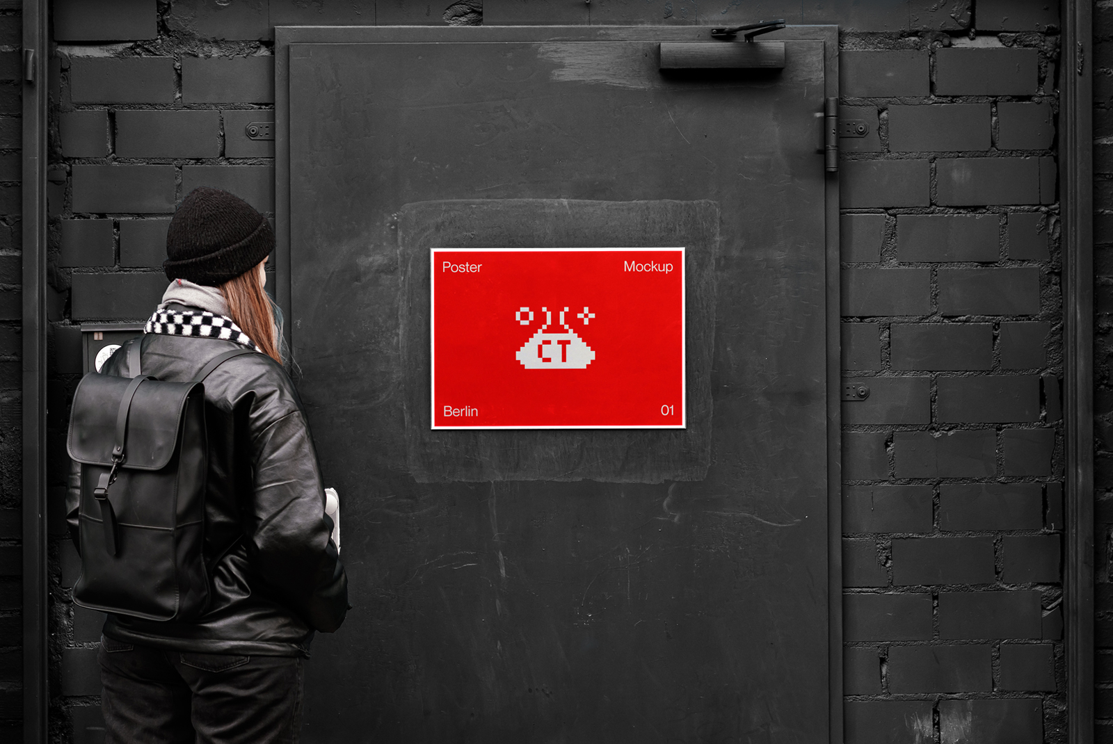 Person viewing a vibrant red poster mockup on a dark urban wall, ideal for designers looking to display graphic work in a realistic setting.
